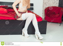 sexy-blonde-school-girl-red-skirt-white-stockings-high-heels-sitting-bed-77425733.jpg
